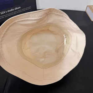 Detalle interior de sombrero de pescador beige con forro de malla transpirable y acabado.