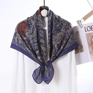 Detailed view of luxury velvet square scarf with paisley floral print and elegant dark blue tones.