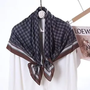 Detailed view of the dark blue geometric patterned velvet square scarf with contrast brown border.