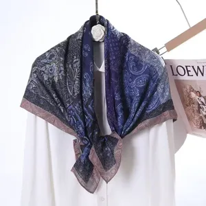 Detailed view of dark blue and purple printed silk scarf, elegant floral paisley design.