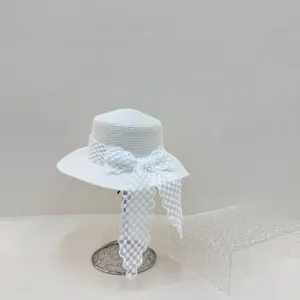 Detailansicht des weißen Damensommer-Strohhutes mit schicker karierter Schleife.