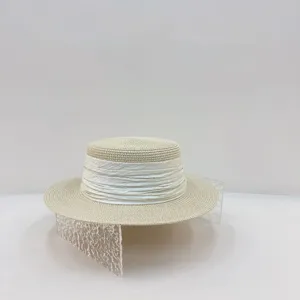 Vue de détail du chapeau de paille élégant avec une texture tissée fine et un ruban chic.