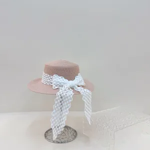 Detailaufnahme des stilvollen flachen Damenstrohhats mit eleganter weißer karierter Schleife.