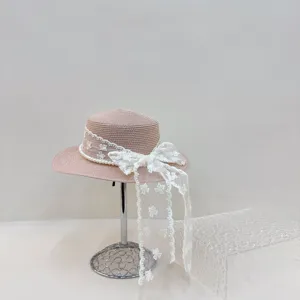 Gros plan sur la bordure en dentelle blanche délicate et les détails de perles du chapeau.