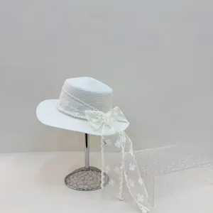 Détail du chapeau de paille d'été blanc avec dentelle, perles et nœud pour la plage.