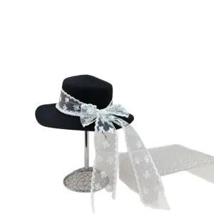 Chapeau de paille noir élégant avec nœud en dentelle blanche et perles pour vacances d'été.