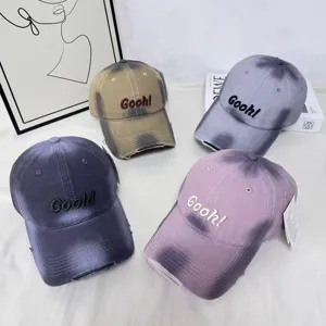 Nahaufnahme von Farbverlauf-Baseballcaps mit abgenutzten Kanten und Stickerei.