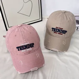 Vista detallada de la gorra de béisbol vintage desgastada con letras bordadas y visera.