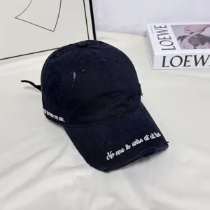 Casquette de baseball noire brodée avec effet usé et texte en anglais dans les détails.