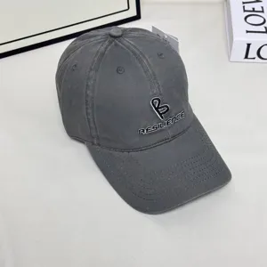 Detailed view of the dark grey embroidered baseball cap with wide brim and stylish letter design.