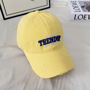 Gorra de béisbol vintage lavada en amarillo, detalle de ala desgastada y elegante bordado.