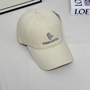 Detail shot of a stylish beige baseball cap featuring fine front embroidery and a curved brim.