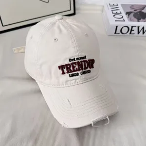Gorra de béisbol vintage lavada con letras bordadas, ala ancha y diseño de parte superior.