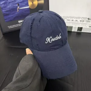 Close-up detail of the navy blue cotton baseball cap showcasing embroidered lettering.