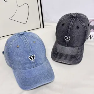 Detailed view of American retro denim baseball caps with pearl heart and number seven embroidery.