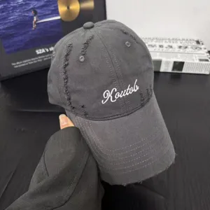 Dark grey cotton distressed baseball cap detail featuring white embroidery and curved brim.
