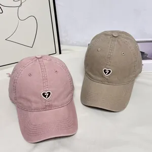 Close-up detail of retro baseball cap with heart pearl embroidery and soft top design.