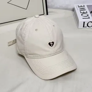 Vintage style off-white baseball cap with embroidered heart and number detail for outdoor daily wear.