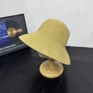 Detailed view of the stylish yellow straw sun hat on wooden stand, ideal for outdoor beach.