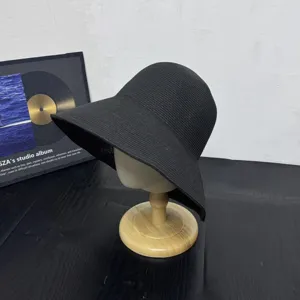 Black straw sun hat detail, wide brim beach hat, casual summer vacation headwear.