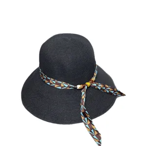 Women's black wide brim straw sun hat with stylish geometric ribbon and wooden bead decor.