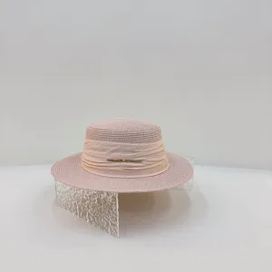 Women summer straw hat detail, flat top design with ribbon and metal bar decoration, elegant.