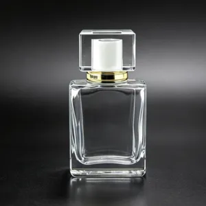 Detail view of the clear glass perfume bottle featuring a square cap and golden collar.
