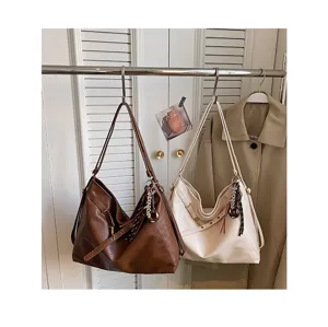 Detailed view of chic faux leather shoulder bags hanging on metal rack, casual commuter style.