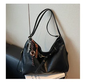 Detail view of a black casual large-capacity leather underarm shoulder bag with charm.