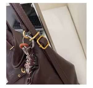 Brown leather shoulder tote bag strap detail, casual minimalist women daily fashion accessory.