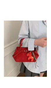 Red leather handbag for women, elegant small tote bag with cute horse charm detail.