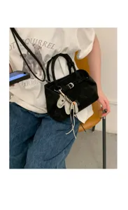 Minimalist black suede handbag with charming animal pendant, chic design for daily stylish wear.