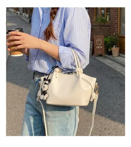 Vue détaillée du sac à main seau minimaliste de mode printanière avec charm chien mignon.