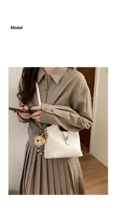 Elegant white leather bucket bag for women, chic shoulder crossbody handbag with cute charm.