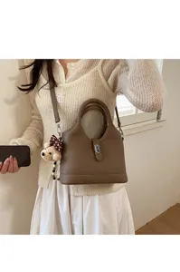 Korean style brown bucket bag with top handle, metal lock and cute bear pendant for women.