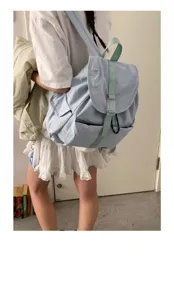Vista dettagliata dello zaino in nylon azzurro casual indossato dalla modella per viaggi.