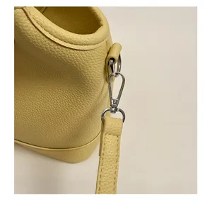 Detailed yellow leather bucket bag strap, chic crossbody bag for daily stylish women.