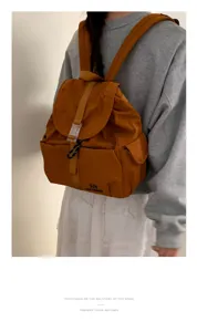 Vista dettagliata dello zaino casual in nylon indossato sulla schiena, che mostra design e tessuto.