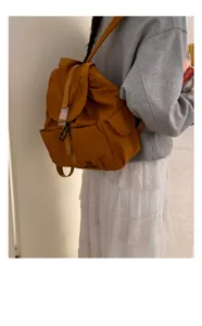 Vista di dettaglio dello zaino casual in nylon giallo senape, con patta anteriore e tasca.