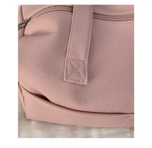 Dettaglio borsa in morbida pelle rosa, primo piano con cuciture raffinate e pratica chiusura lampo.