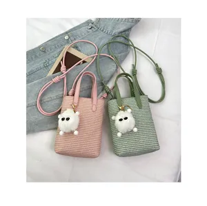 Detailansicht der kleinen gewebten Eimer Tasche mit niedlichem Plueschanhaenger, ideal.