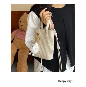 Kleine geflochtene Umhängetasche für Damen, modische Sommer Mini Handtasche mit süßem Plüschanhänger.