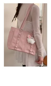 Detailed view of the pink pu shoulder tote bag with cute plush pendant and metal ring decor.