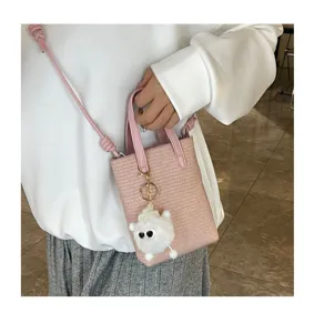 Detailansicht der rosa Mini Umhängetasche für Handys mit flauschigem Anhänger und feiner Textur.