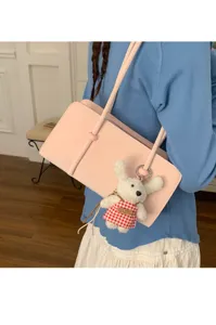 Minimalist pink leather underarm shoulder bag for women with cute plush bunny pendant.