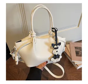 Vue détaillée d'un sac à main blanc élégant avec charm de chien mignon pour le quotidien.
