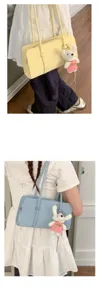 Close-up detail of the stylish underarm shoulder bag with cute plush rabbit keychain.