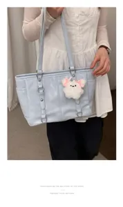 Light blue PU leather commuter tote bag detail showing cute white plush charm pendant.