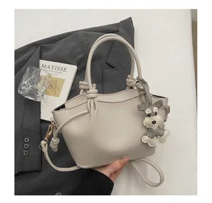 Sac à main beige minimaliste avec poignées nouées et charm chien mignon, élégant sac bandoulière.