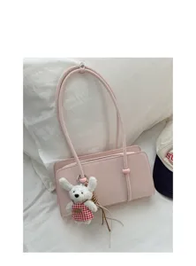 Detailed view of the pink shoulder underarm bag with a cute plush rabbit charm decoration.